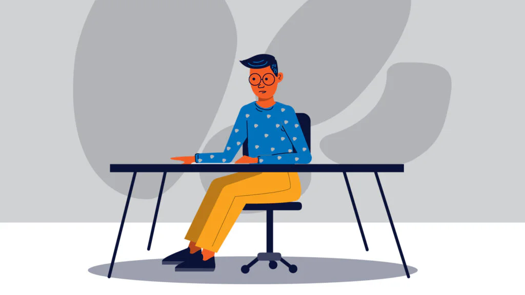 Med student at a desk against a grey background