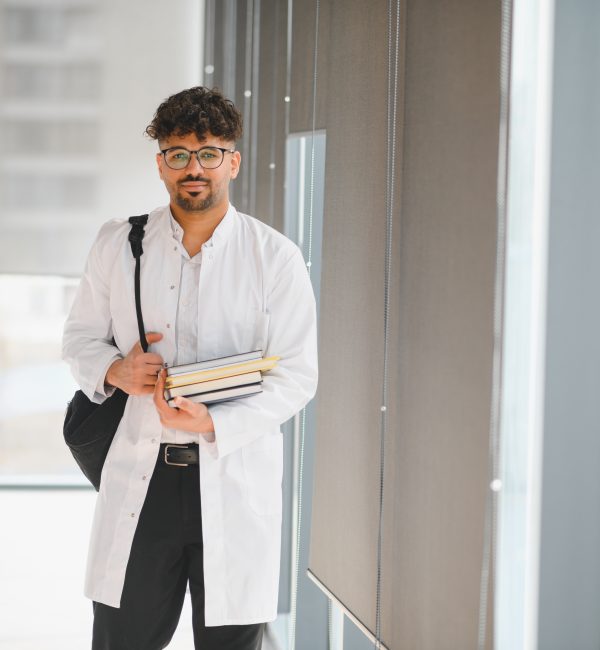 medical student carrying books in university hallway
